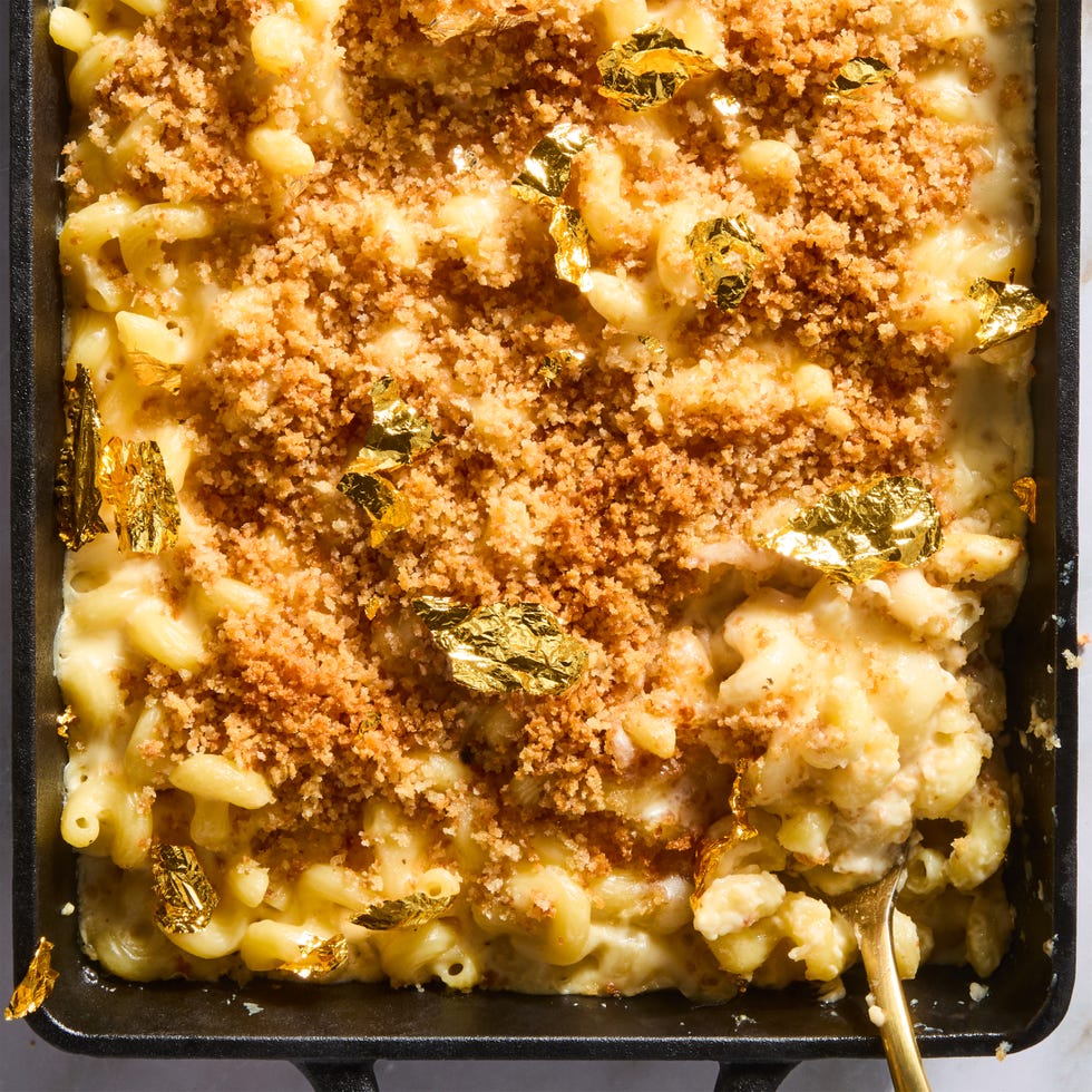 million dollar mac and cheese topped with panko breadcrumbs and gold leaf in a cast iron pan