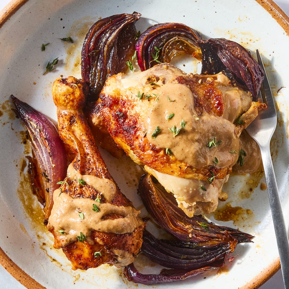 paprika dusted chicken roasted on a bed of herby sliced red onions and whole garlic cloves then topped with an umami rich, spoonable sauce made from chicken fat roasted, charred onions, butter, sweet white vinegar, and crushed red pepper
