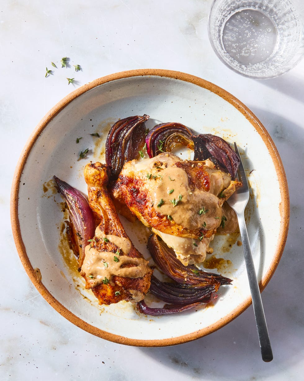 paprika dusted chicken roasted on a bed of herby sliced red onions and whole garlic cloves then topped with an umami rich, spoonable sauce made from chicken fat roasted, charred onions, butter, sweet white vinegar, and crushed red pepper