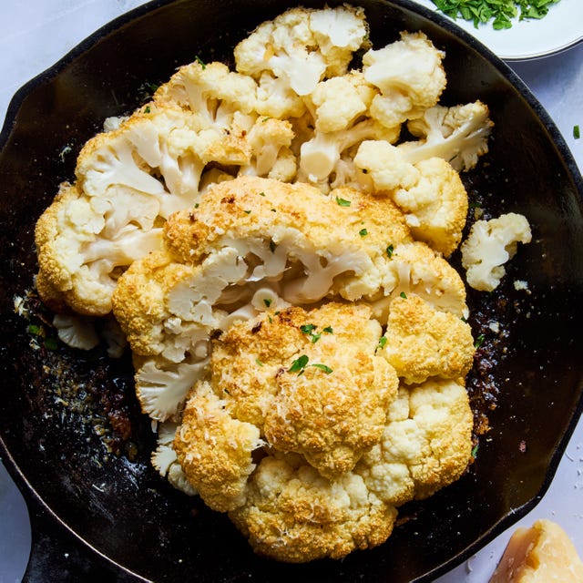 whole roasted cauliflower sliced in a cast iron skillet