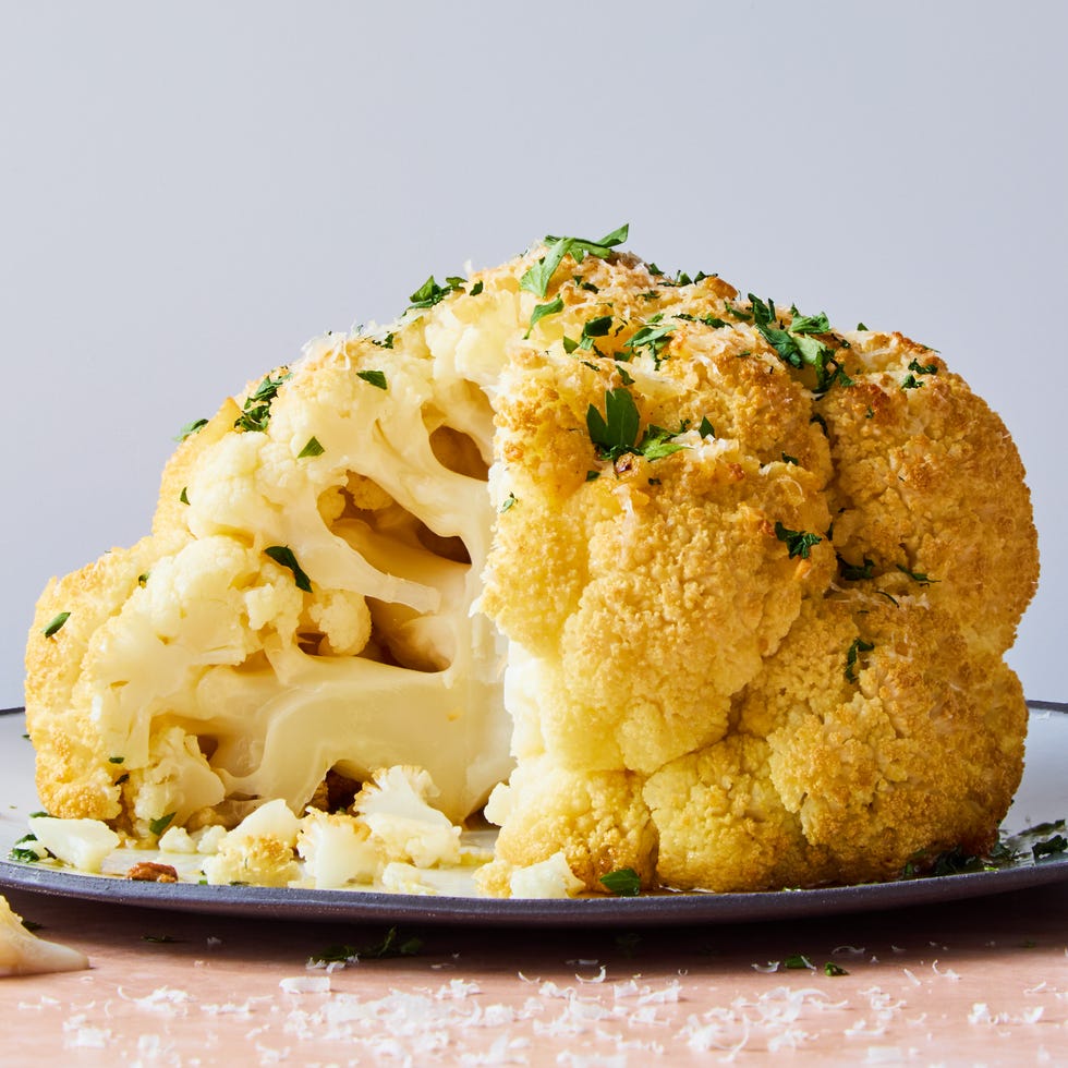 whole roasted cauliflower on a platter topped with parsley