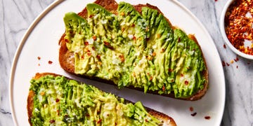 olive oil toasted whole wheat sourdough bread topped with ripe avocado, garlic, lemon juice, and red pepper flakes