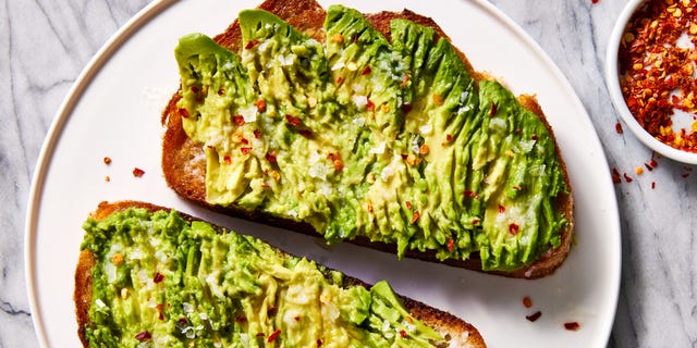 olive oil toasted whole wheat sourdough bread topped with ripe avocado, garlic, lemon juice, and red pepper flakes