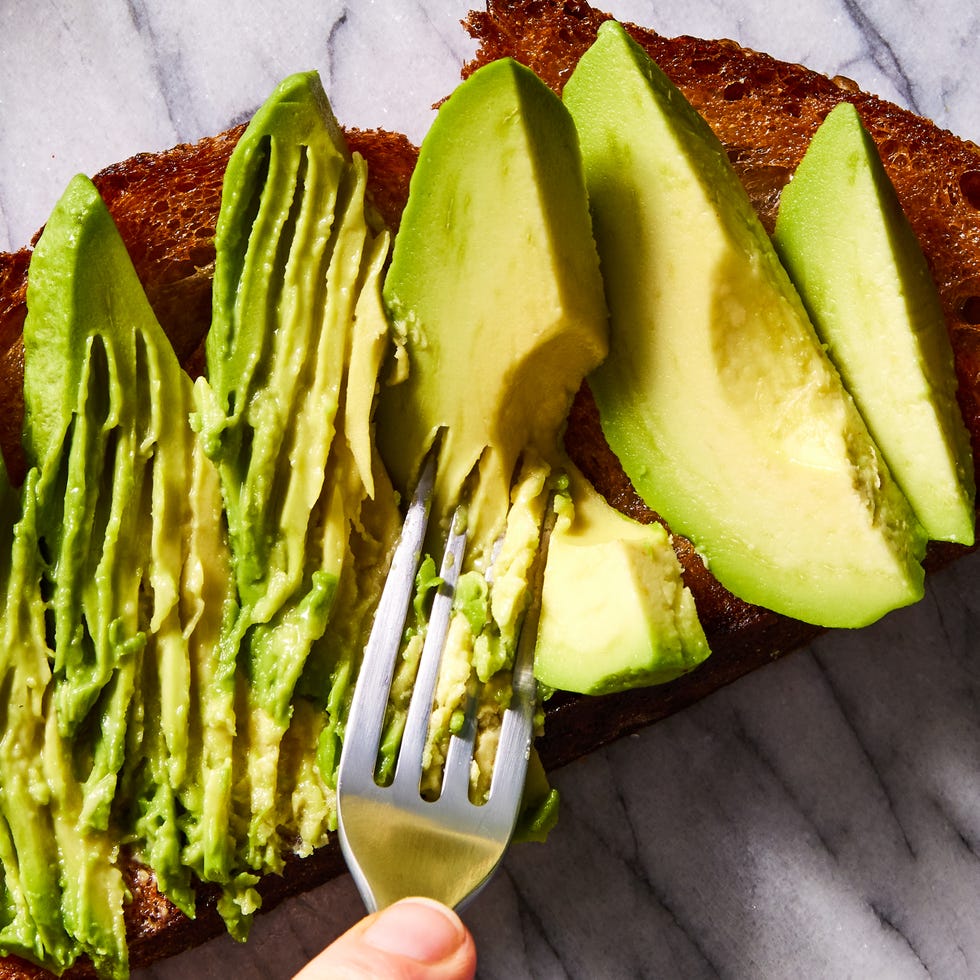 olive oil toasted whole wheat sourdough bread topped with ripe avocado, garlic, lemon juice, and red pepper flakes