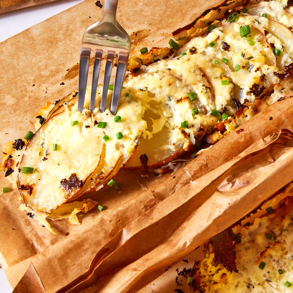 thinly sliced potatoes layered with herbed garlicky cream cheese, gruyere, and parmesan, then roasted in a parchment pouch