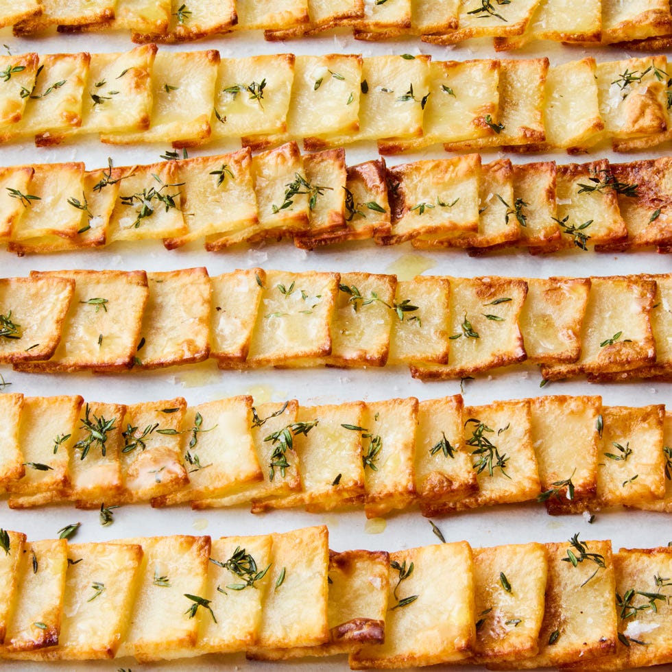 crispy domino potatoes in rows topped with thyme and flaky salt