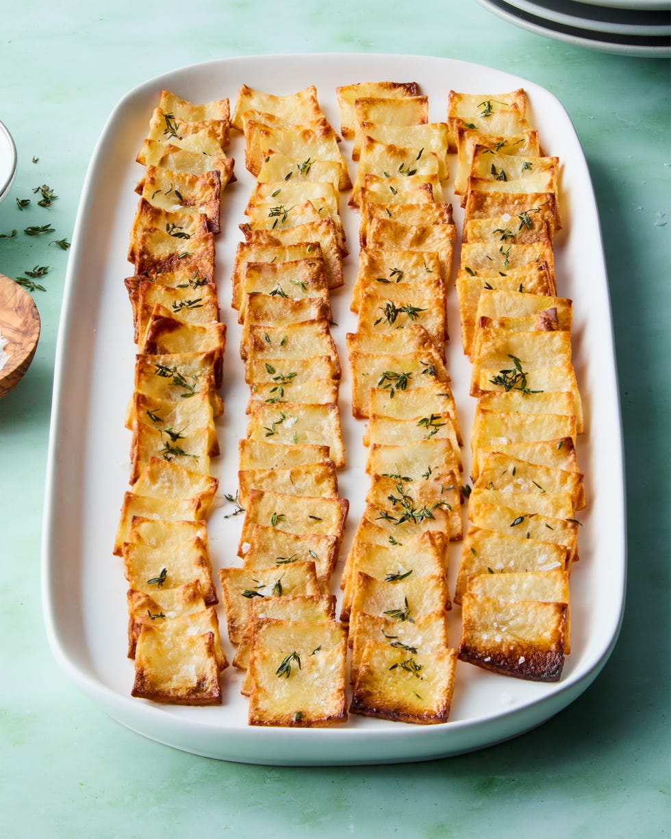 crispy domino potatoes on a white platter topped with thyme