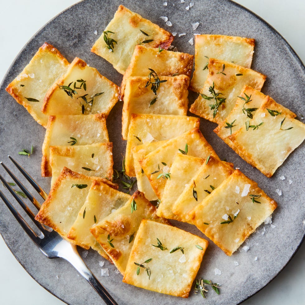 crispy domino potatoes on a plate topped with thyme and flaky salt