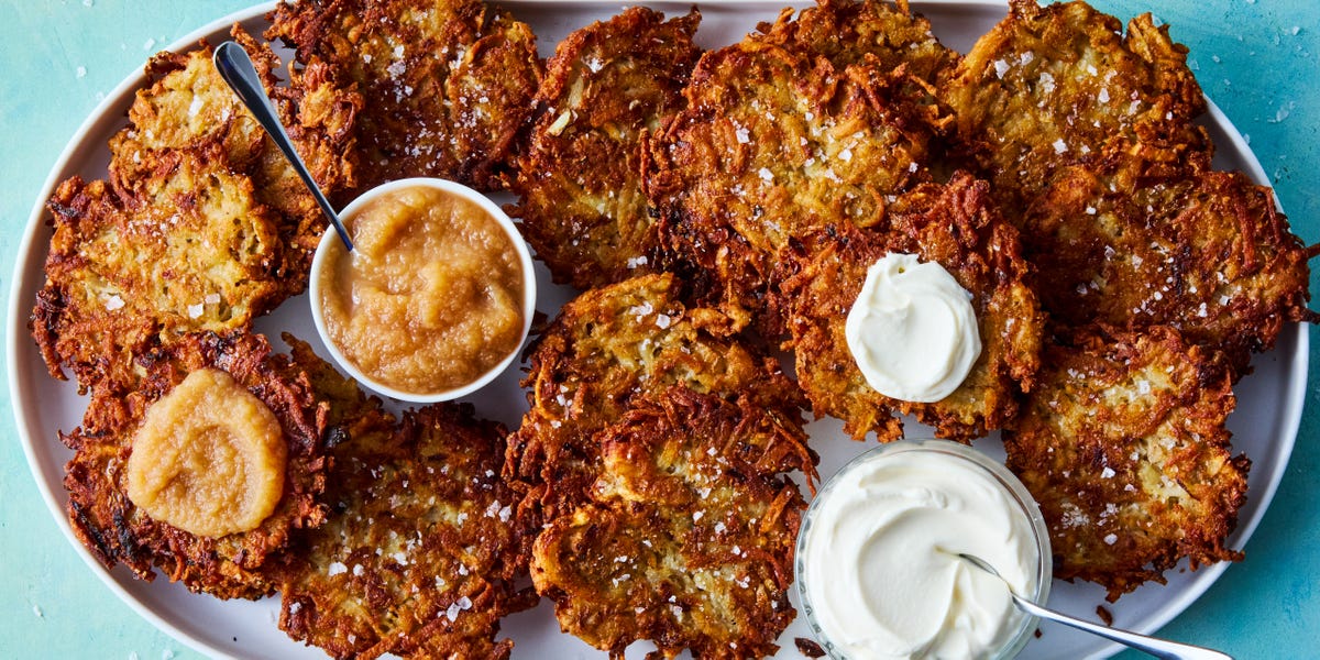crispy latkes on a platter with bowls of sour cream and applesauce