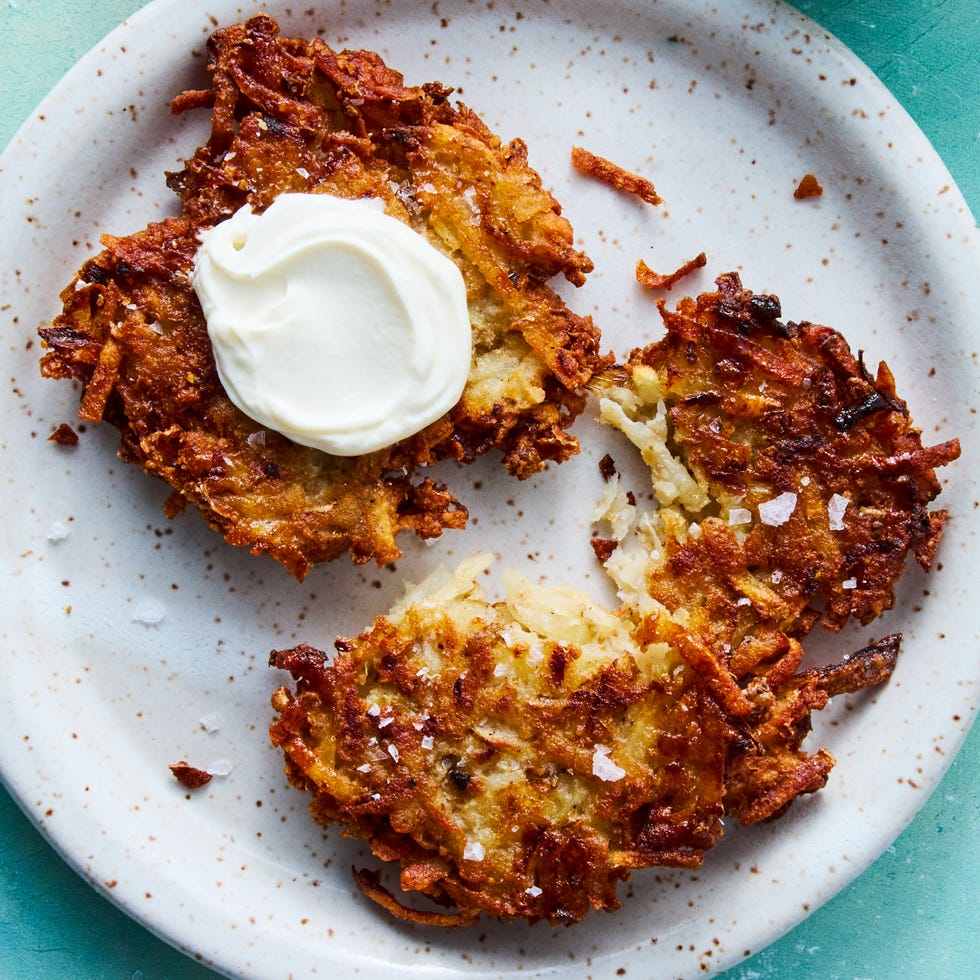 crispy latkes on a plate topped with sour cream