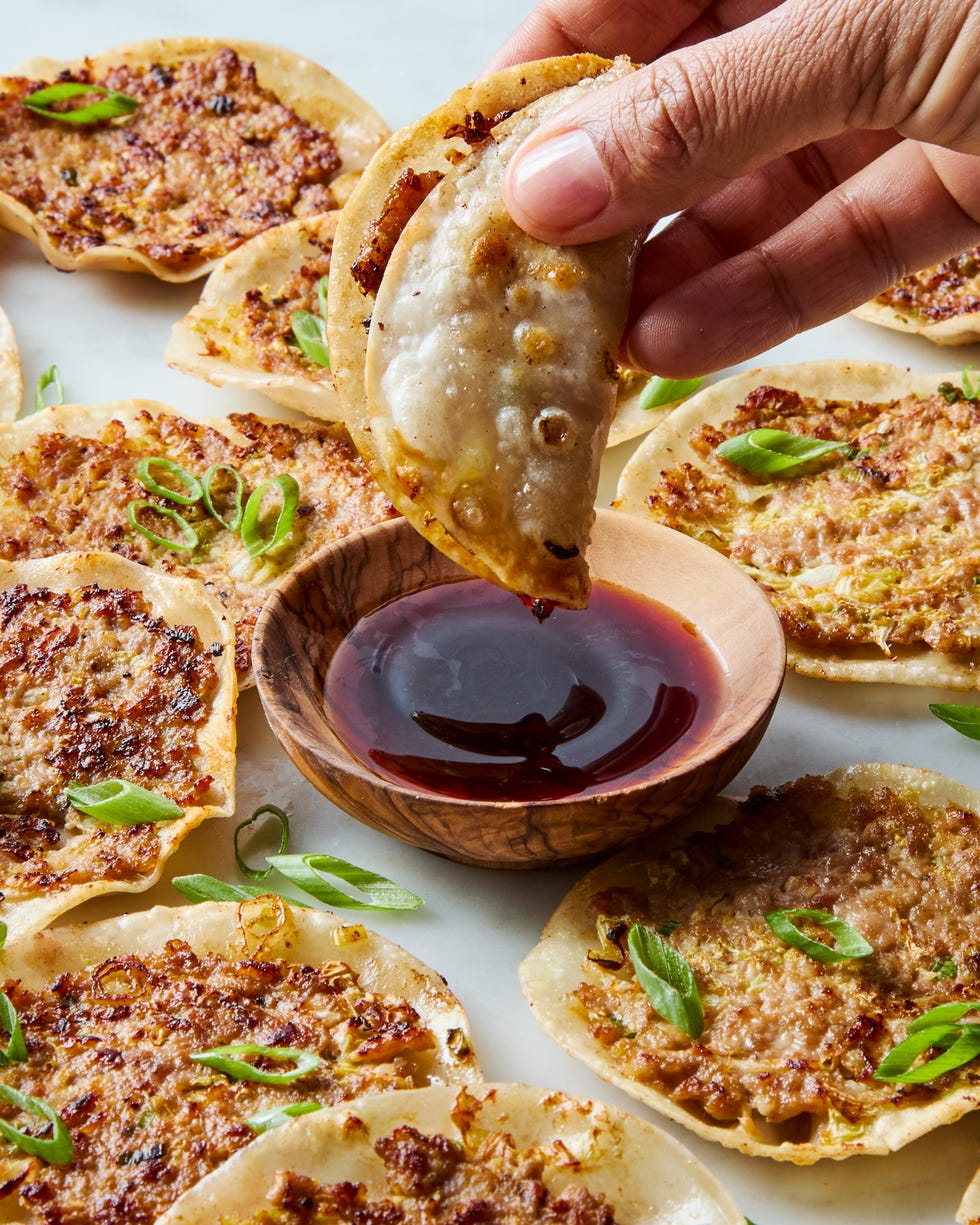 smash dumpling being dipped into a bowl of soy sauce