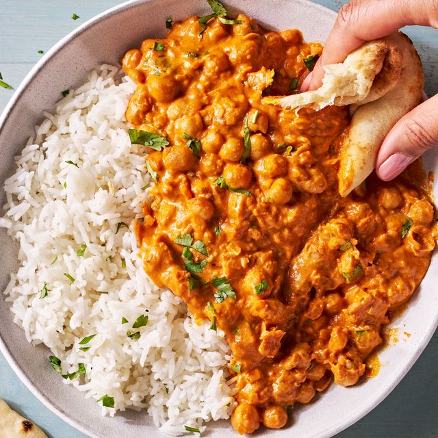 indian butter chickpeas and rice in a bowl with pita