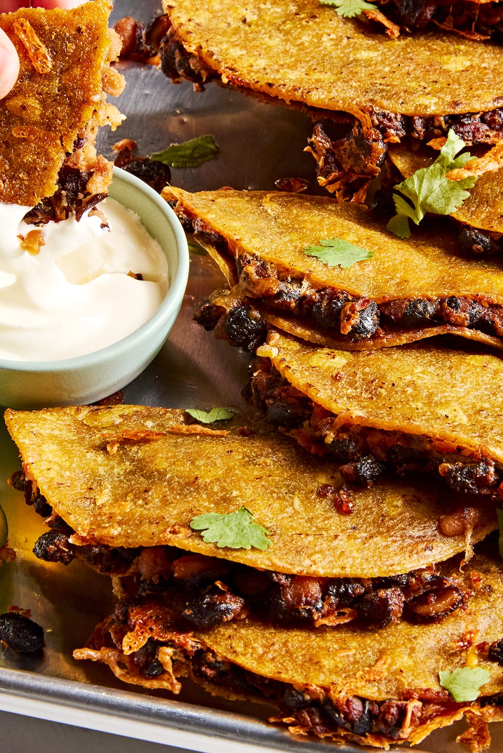 Crispy sheet pan black bean tacos crispy sheet pan black bean tacos on a sheet pan with one dipped into a bowl of sour cream