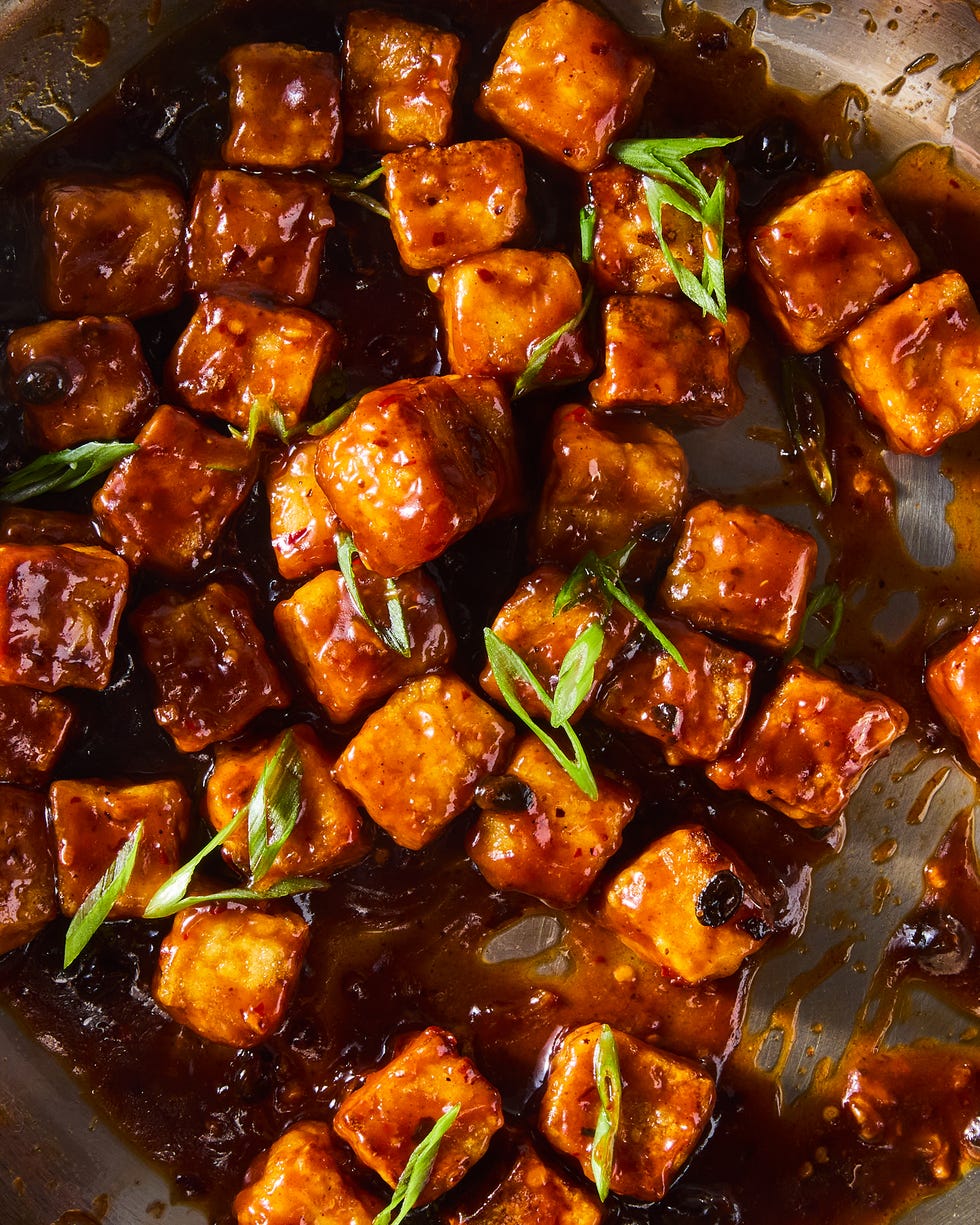 chili crisp fried tofu in a pan topped with scallions