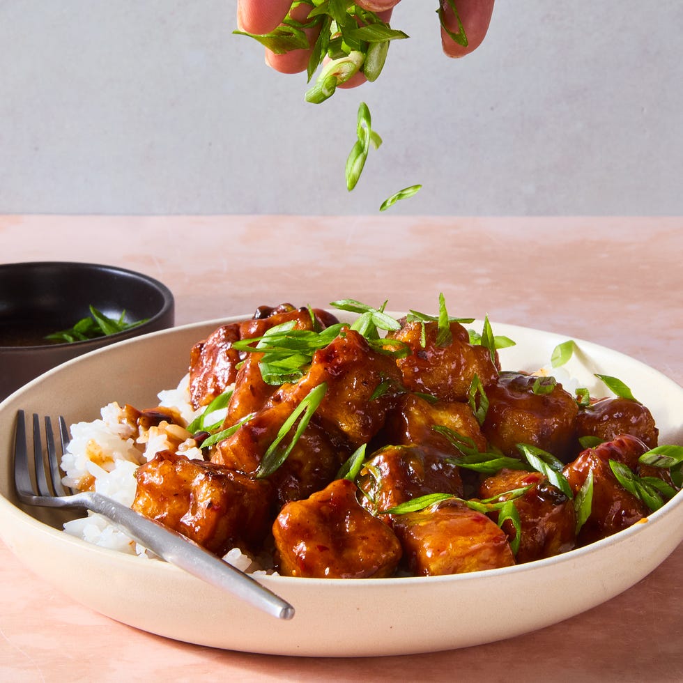 chili crisp fried tofu in a bowl on top of rice topped with scallions