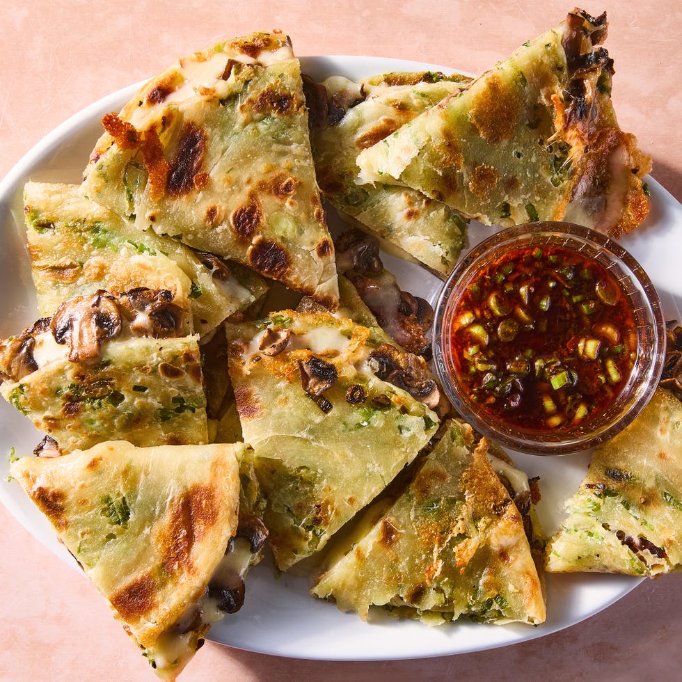 flaky scallion pancakes are fried to golden brown perfection then transformed into quesadillas stuffed with melty mozzarella and umami packed spiced mushrooms and paired with a tangy soy scallion dipping sauce