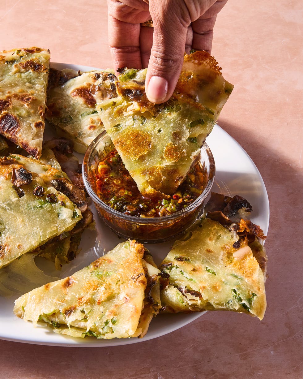 flaky scallion pancakes are fried to golden brown perfection then transformed into quesadillas stuffed with melty mozzarella and umami packed spiced mushrooms and paired with a tangy soy scallion dipping sauce