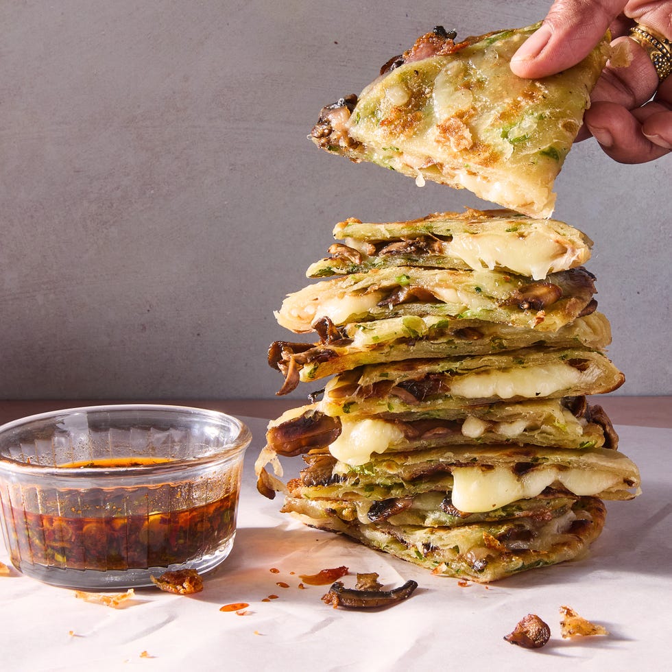 flaky scallion pancakes are fried to golden brown perfection then transformed into quesadillas stuffed with melty mozzarella and umami packed spiced mushrooms and paired with a tangy soy scallion dipping sauce