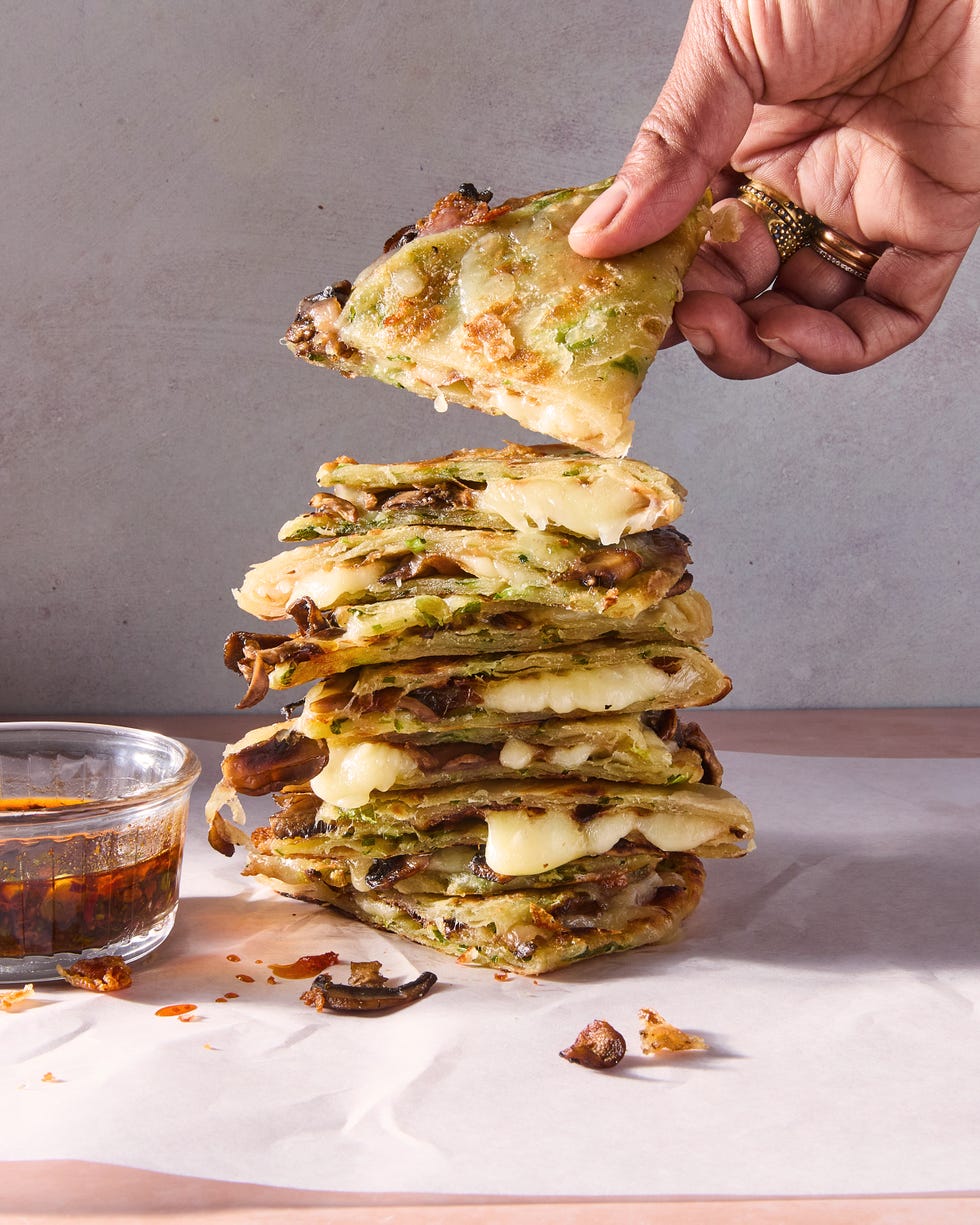flaky scallion pancakes are fried to golden brown perfection then transformed into quesadillas stuffed with melty mozzarella and umami packed spiced mushrooms and paired with a tangy soy scallion dipping sauce