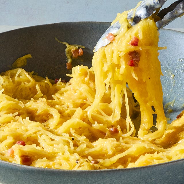 lifting spaghetti squash carbonara from a bowl with tongs