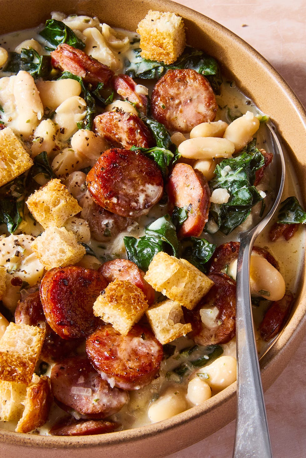 White Bean & Smoked Sausage Skillet seared smoked sausage smothered in a creamy boursin sauce tossed with tender cannellini beans and kale hen topped with crunchy homemade mini croutons