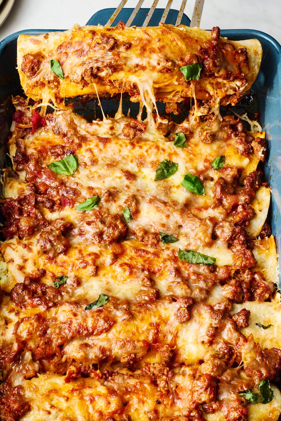 Lasagnchiladas saucy beef bolognese, and herby ricotta rolled into flour tortillas and topped with more bolognese mozzarella and parmesan then baked until bubbly and perfect