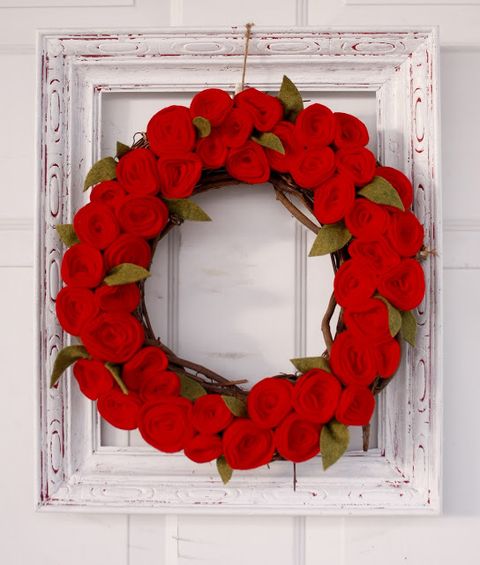 faux red rose wreath made out of rosettes in a distressed white frame