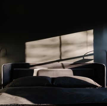 an all black bedroom with a dramatic light coming in from the window