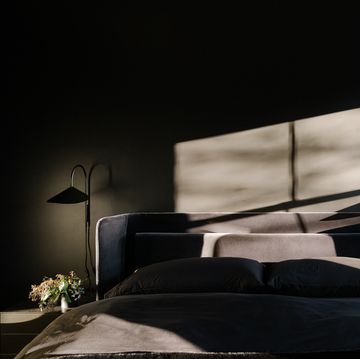 an all black bedroom with a dramatic light coming in from the window