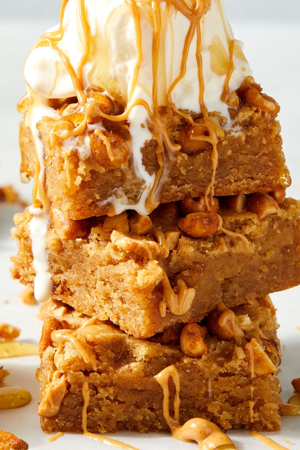 stack of honey and peanut butter blondies topped with melty ice cream and honey