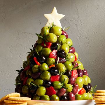cheese ball shaped like a christmas tree and covered in olives and rosemary