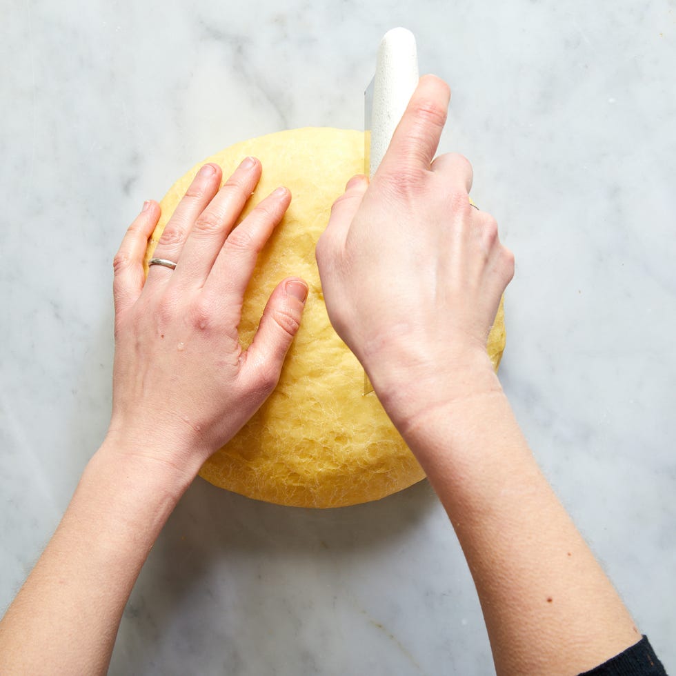 circle of dough being cut in half