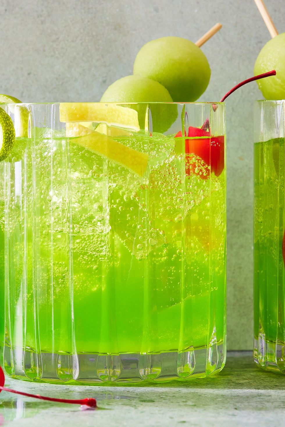 midori sour with melon balls and cherries