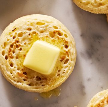 crumpet topped with butter and surrounded by more crumpets