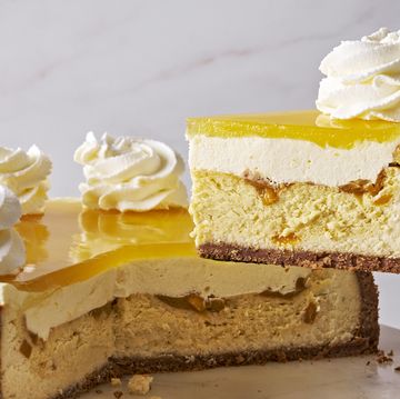 mango key lime cheesecake with vanilla coconut crust, layered with mango mousse, and mango glaze, and topped with whipped cream