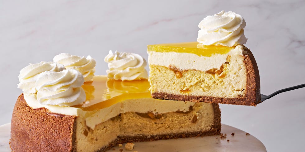mango key lime cheesecake with vanilla coconut crust, layered with mango mousse, and mango glaze, and topped with whipped cream