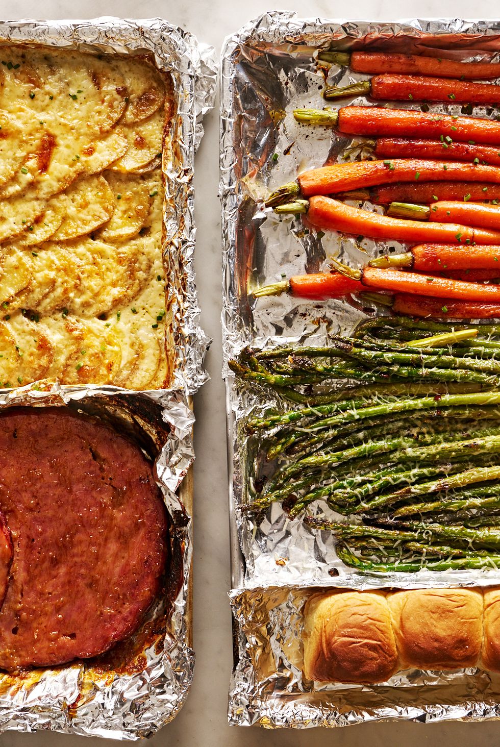 sheet pan easter dinner with glazed ham, gruyere scalloped potatoes, roasted carrots, roasted asparagus, and rolls