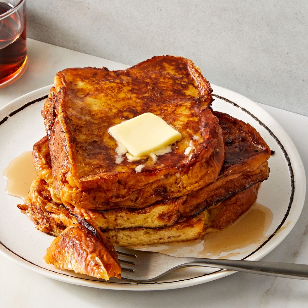 stack of french toast on a plate topped with butter and maple syrup