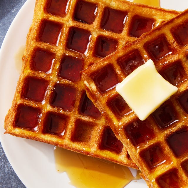 square classic waffles topped with butter and drizzled with maple syrup