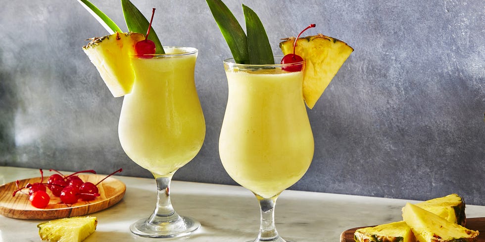 frozen pina colada cocktail with dark rum garnished with a maraschino cherry and pineapple wedge