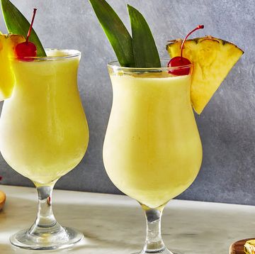 frozen pina colada cocktail with dark rum garnished with a maraschino cherry and pineapple wedge