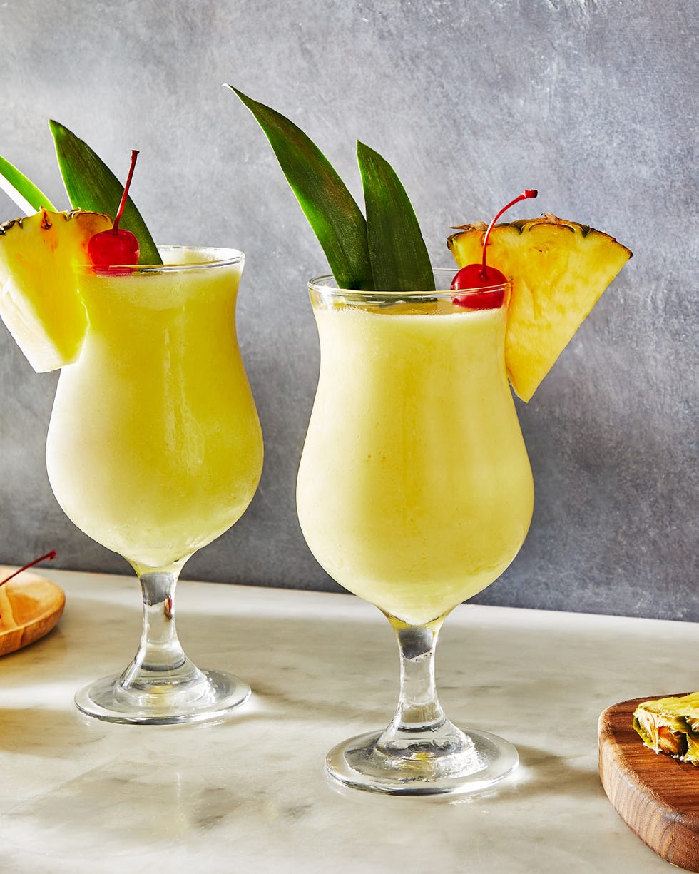 frozen pina colada cocktail with dark rum garnished with a maraschino cherry and pineapple wedge