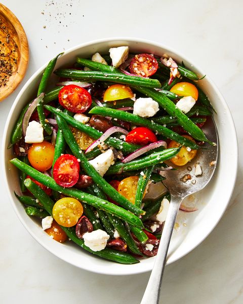green bean salad with tomatoes and feta in a bowl with a spoon