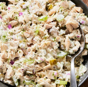 tuna salad in a bowl beside sliced wheat bread