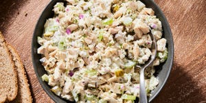 tuna salad in a bowl beside sliced wheat bread