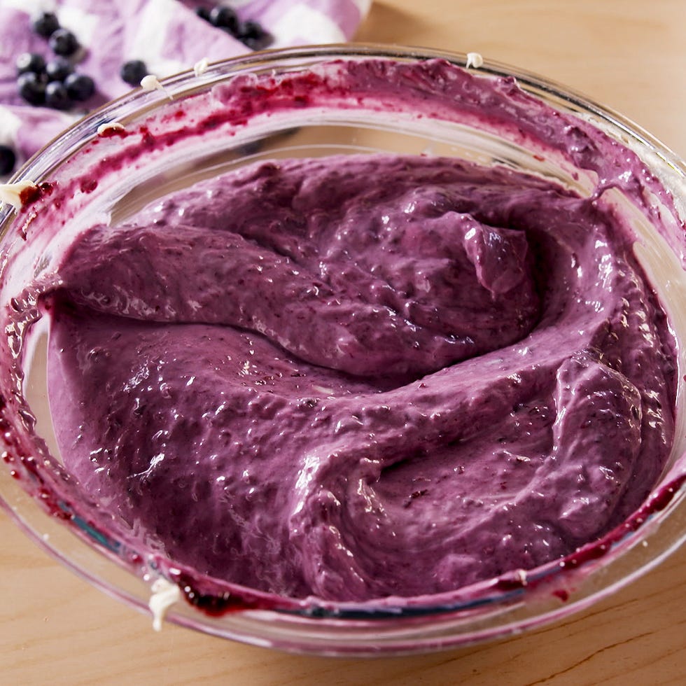 mixing blueberry cheesecake filling in a large bowl.
