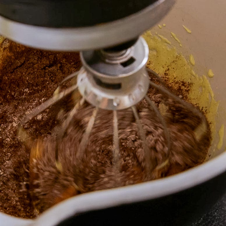 a mixing bowl with batter being mixed by a stand mixer