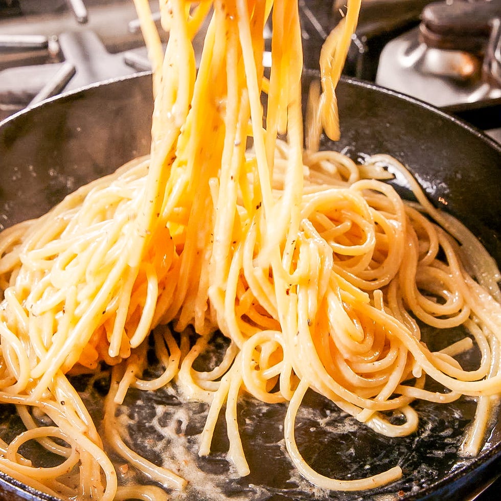 spaghetti being lifted from a pan