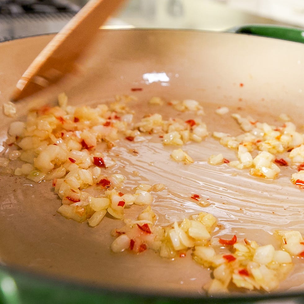 chopped onions and red pepper flakes being cooked in a skillet