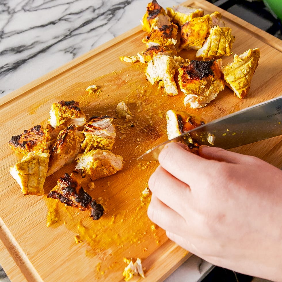 chicken on a cutting board being cut up